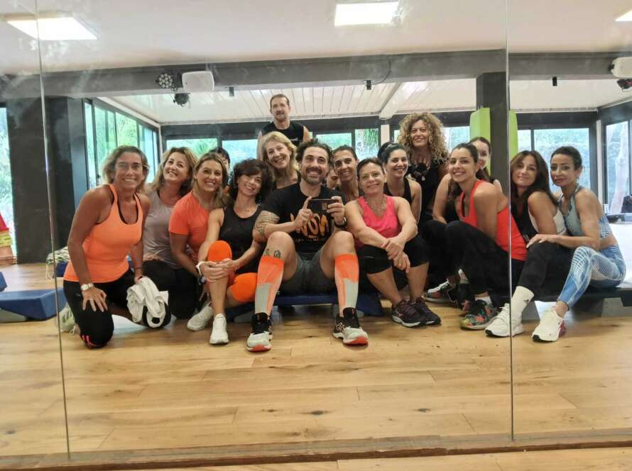 Donne e uomini si riuniscono per una foto divertente in un ambiente di palestra.